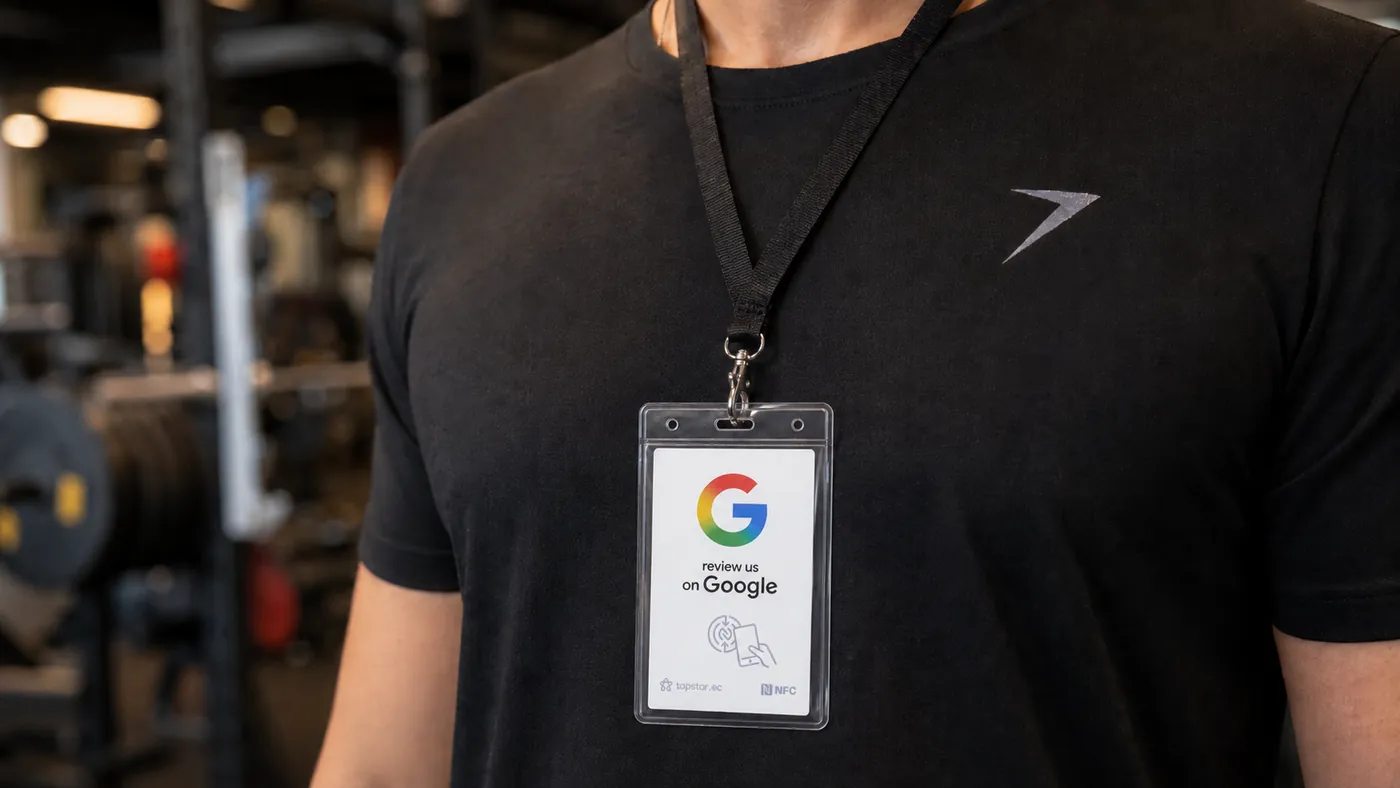 Miembro de un gimnasio en Ecuador celebrando un logro y dejando una reseña en Google en recepción con un toque a una tarjeta Tapstar.